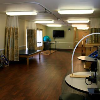 A spacious rehabilitation therapy room featuring equipment and natural light.
