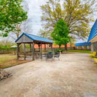 A serene outdoor patio area featuring a gazebo, seating, and lush greenery.