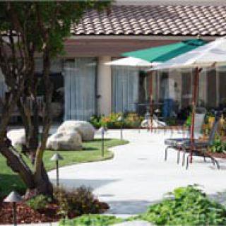A well-maintained garden patio with outdoor seating and umbrellas.