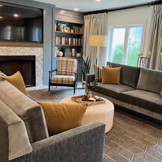 A cozy living room with a fireplace, comfortable sofas, and a stylish bookshelf.