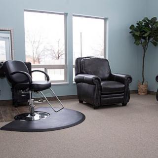 A modern salon interior with comfortable seating and a barber chair.