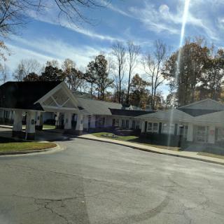 A view of a residential or commercial building surrounded by trees and clear skies.