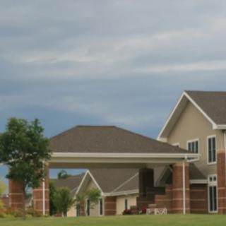 A suburban house with a driveway under a cloudy sky.