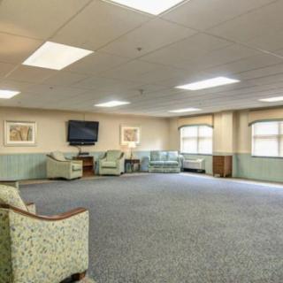 A spacious lounge area with comfortable seating and a mounted television.