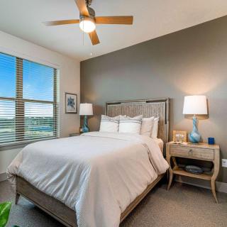 A modern bedroom featuring a comfortable bed, stylish lamps, and a large window with a scenic view.