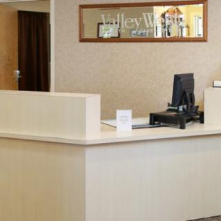 A reception desk with a computer setup in an office environment.