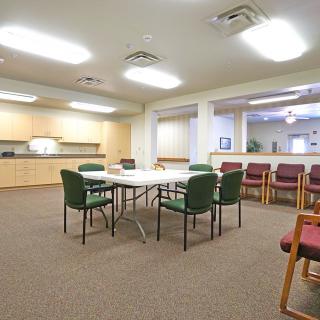 A well-lit meeting room with a central table and chairs, suitable for conferences or group discussions.