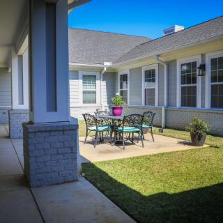 A cozy outdoor patio area with a dining table and chairs set in a sunny courtyard.
