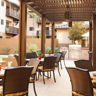 A cozy outdoor patio with tables and chairs under a pergola, ideal for relaxation.