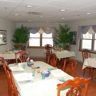 A cozy dining room with neatly arranged tables and chairs, set for a meal.