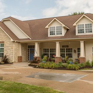 A suburban residential house with a manicured front yard and driveway.