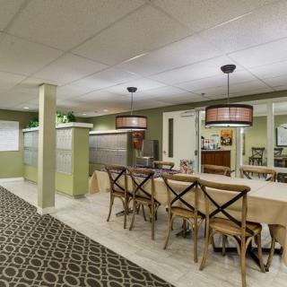A modern dining area featuring wooden chairs and tables, elegant lighting fixtures, and stylish decor.