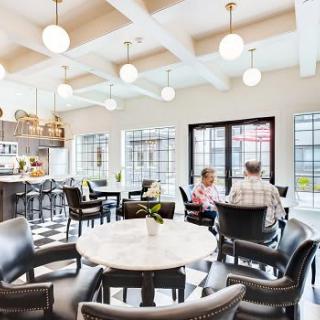 A cozy cafe interior with people socializing at tables under soft lighting.