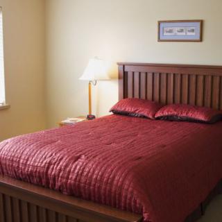 A cozy bedroom with a wooden bed and red bedding.