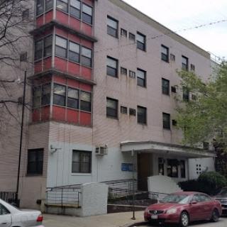 A view of a multi-story residential building with distinctive architectural features.