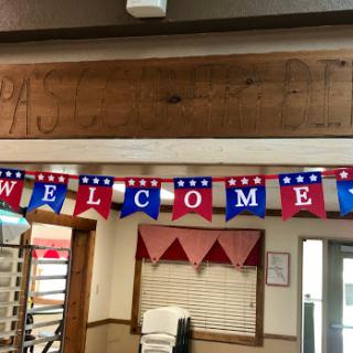 A festive welcome banner displaying red, white, and blue decorations.