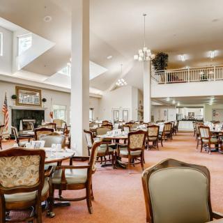 A spacious dining area with elegant furniture and skylights.
