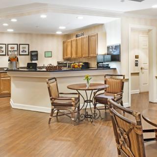 A cozy kitchen and dining area with wooden cabinets and flooring, featuring a round table and chairs.