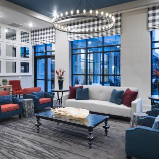 A modern living room with stylish furniture and a large chandelier.