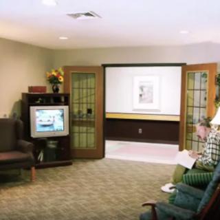 A cozy waiting room with a television, comfortable chairs, and decor.