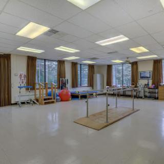 A spacious and well-lit physical therapy room equipped for rehabilitation exercises.