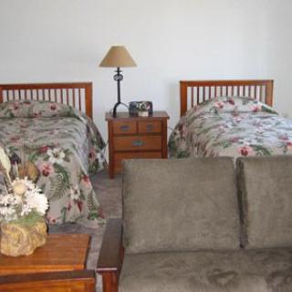 A cozy bedroom with twin beds, a nightstand, and a sofa.