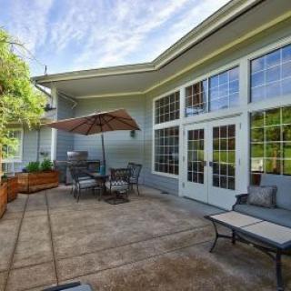 A cozy outdoor patio with seating and a large umbrella.