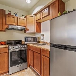 A modern kitchen with wooden cabinets and stainless steel appliances.