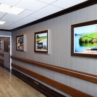A hospital hallway with framed paintings on the wall.