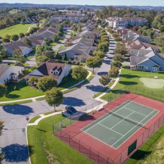 Aerial view of a suburban neighborhood with a tennis court.