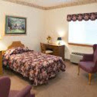 A cozy bedroom with a single bed, decorative elements, and comfortable seating.