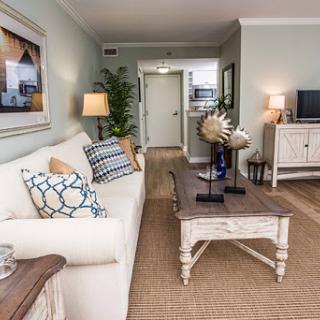 A beautifully designed living room featuring light-colored walls, comfortable seating, and stylish decor elements.