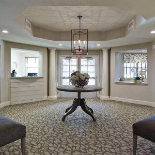 A well-lit lobby with a central table and elegant decor.