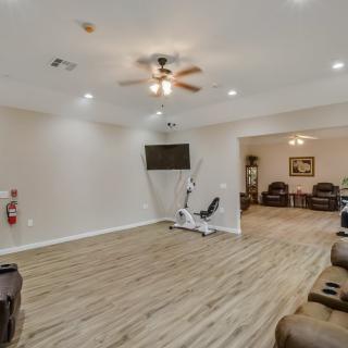 A spacious exercise room with gym equipment and wooden flooring.