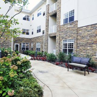 A view of an apartment building's courtyard with benches and landscaping.