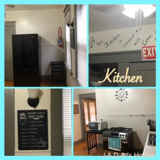 A cozy kitchen with modern appliances, featuring a chalkboard menu and decorative wall art.