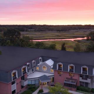 A beautiful hotel with a scenic sunset view over a river and lush landscape.