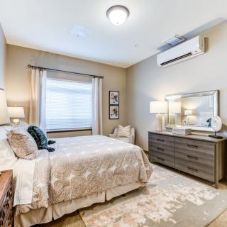 A cozy bedroom featuring a comfortable bed, stylish dresser, and elegant decor with soft lighting.
