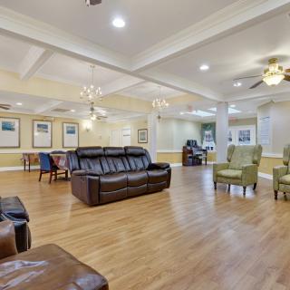 A spacious and well-lit living room with comfortable seating and wood flooring.