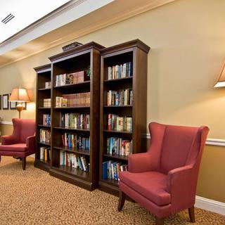 A cozy reading area with armchairs and a bookshelf filled with books.