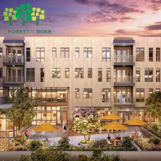 A modern apartment complex featuring outdoor seating and beautifully landscaped gardens during sunset.