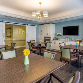 A modern dining area with tables and chairs, featuring elegant decor and bright lighting.