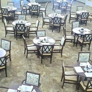 An empty restaurant dining area with neatly arranged tables and chairs.