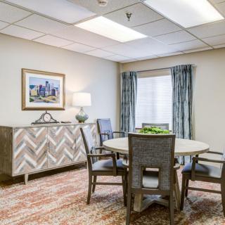 A well-lit dining room with a round table, several chairs, and tasteful decor.