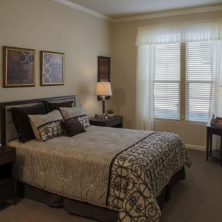 A cozy bedroom featuring a neatly made bed, soft lighting, and elegant decor.