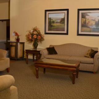 A cozy living room with a sofa, coffee table, and framed pictures on the wall.