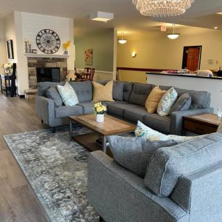 A cozy living room with modern furniture, featuring a chandelier and stylish decor.