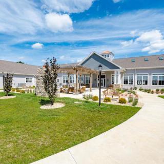 A scenic view of a modern residential building with well-maintained gardens and clear blue skies.