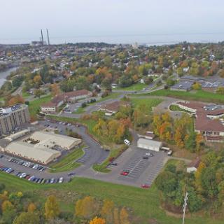 An aerial view of a city landscape showcasing autumn colors and various buildings.