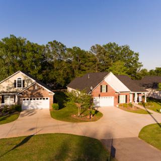 A picturesque aerial view of a suburban neighborhood featuring beautifully designed houses and lush greenery.